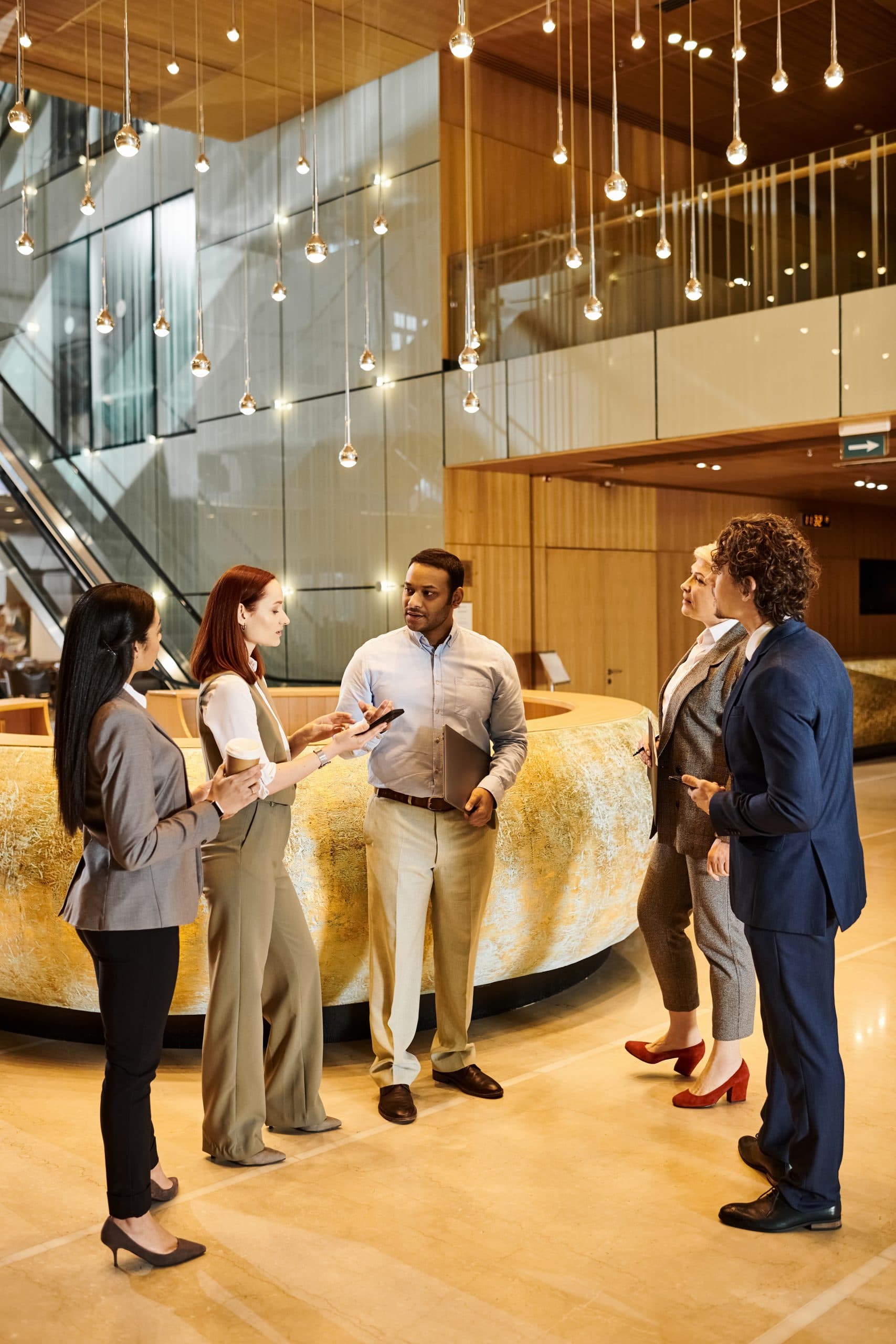 Profesionales conversando en el lobby de un edificio corporativo moderno